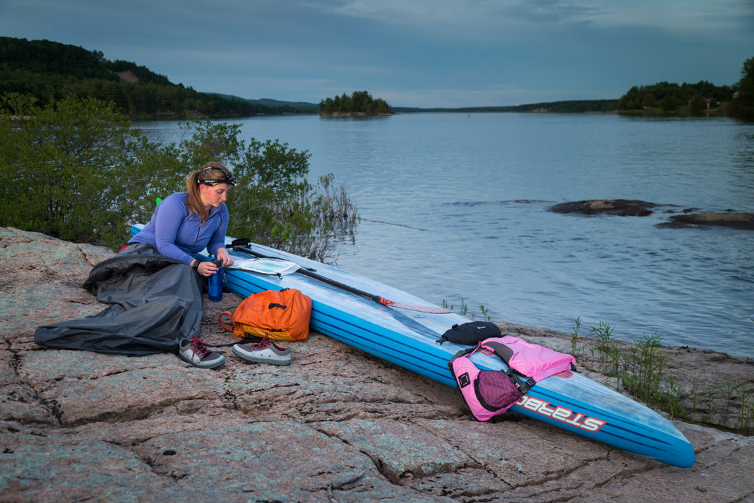 woman surrounded by paddlboarding gear