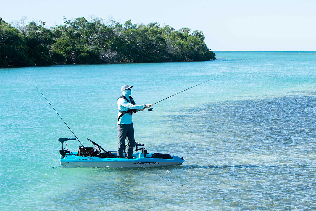 angler stands and fishes from Pelican Catch Pwr 100 kayak