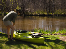 woman prepares a Sun Dolphin kayak to enter the water