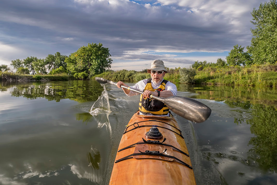 man paddles a build-your-own wooden kayak