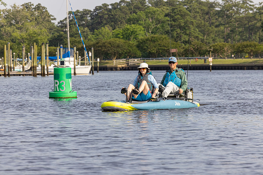 young woman and older man pedal the Hobie Mirage iTrek 14 Duo tandem inflatable fishing kayak