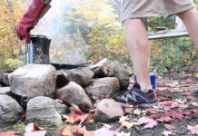 person demonstrates how to makes cowboy coffee at a campsite