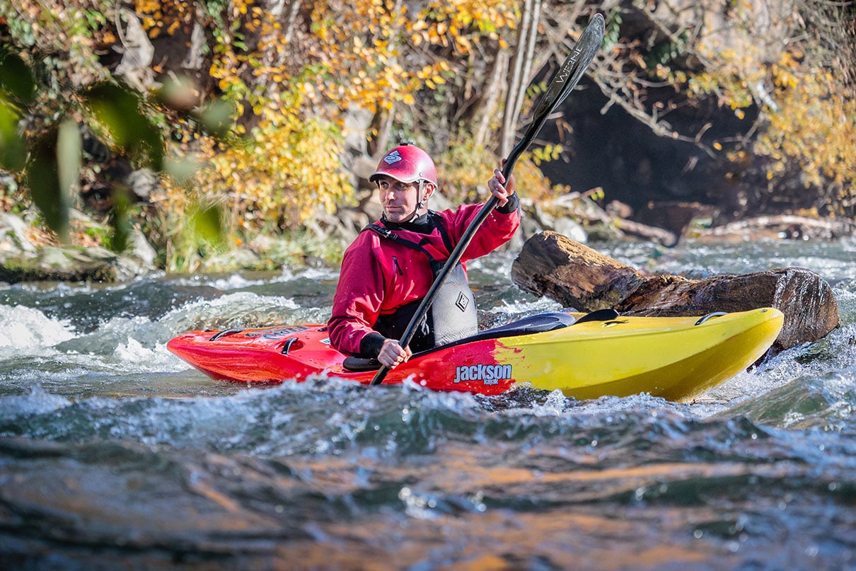 Man paddles the new Jackson Kayak Flow creek boat down a rapid.