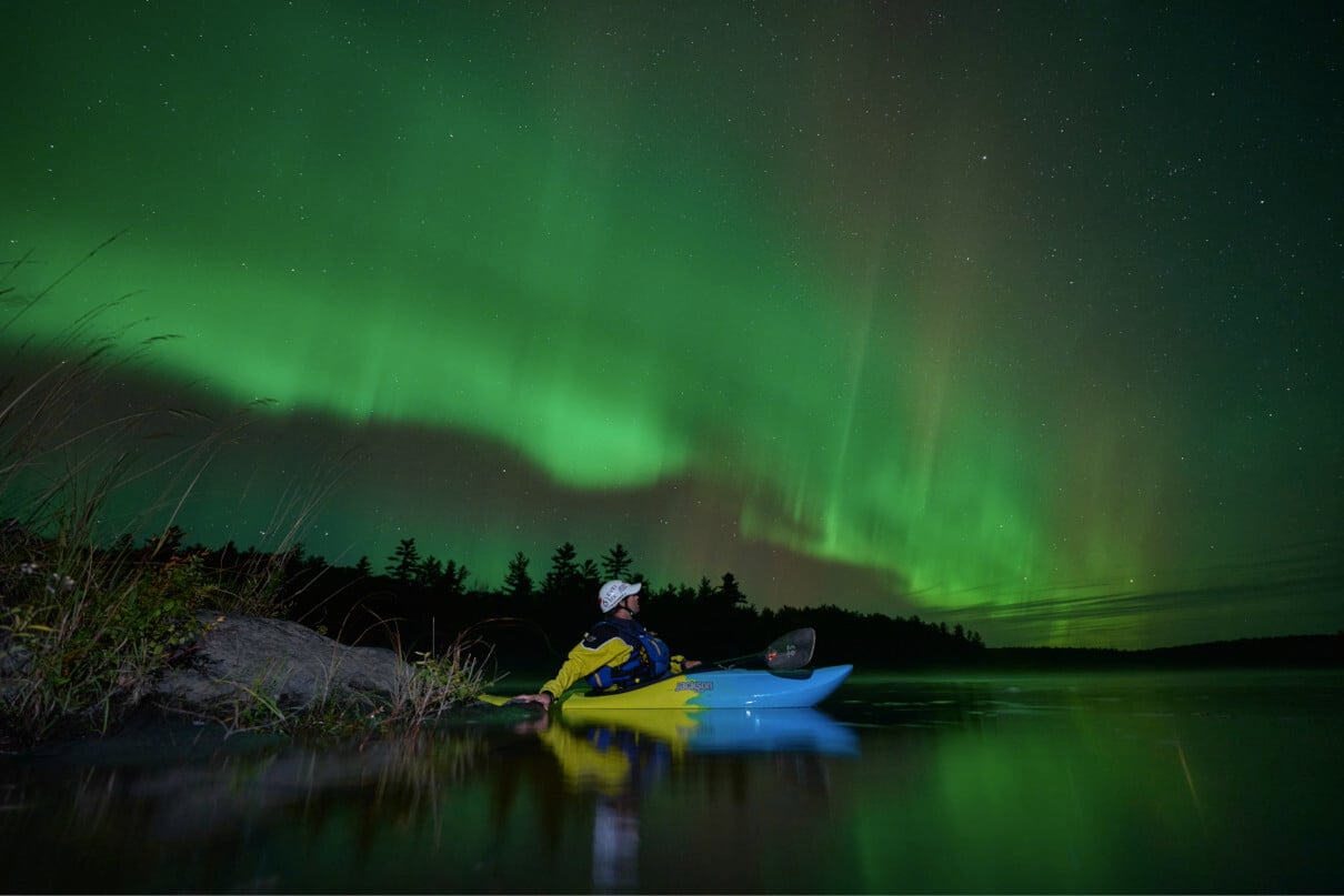 The Northern Lights on the Ottawa River over whitewater kayaker Joel Kowalski