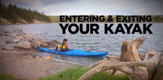 Paddler demonstrates how to get in a kayak.