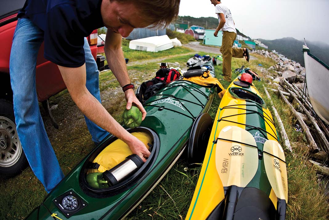 man packs for lightweight kayak camping trip