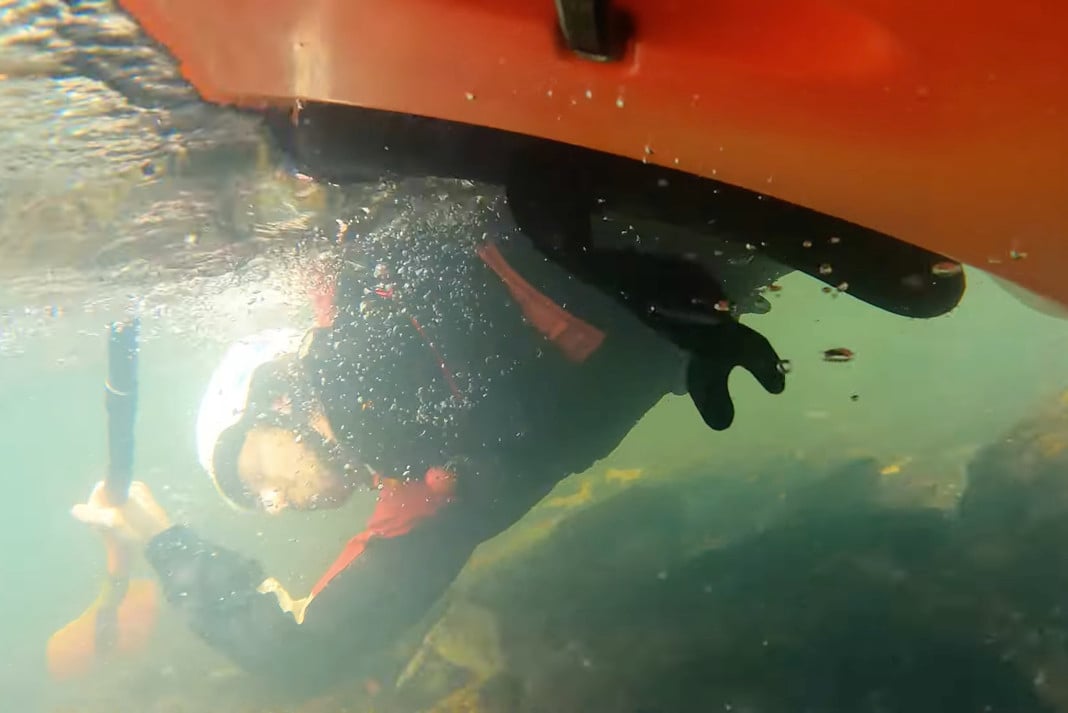Underwater view of a back deck kayak roll.