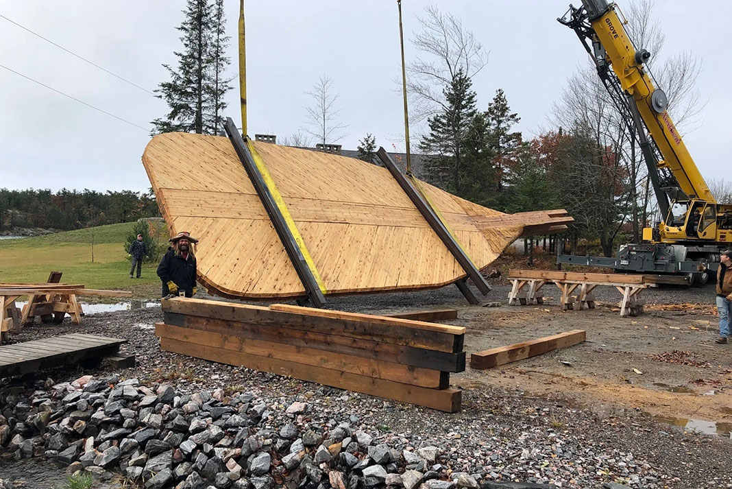 Mike Ranta stands beside his giant Big Dipper paddle as it is installed by a crane